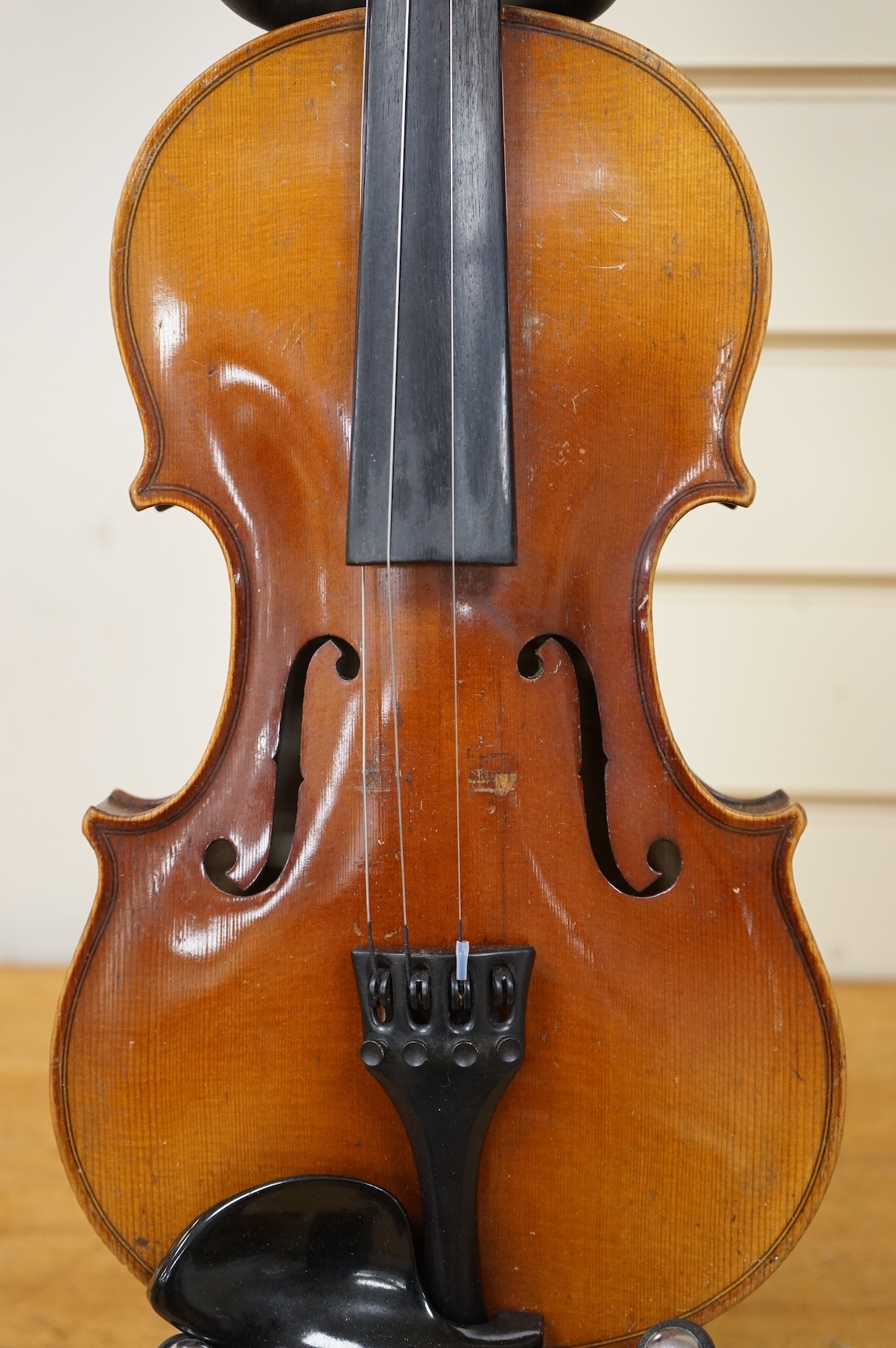 Five cased 20th century violins, including; a German violin, two Czech violins, a three-quarter size violin with a label for Bienfait, and a Romanian quarter size violin, all in cases or the remains of cases.